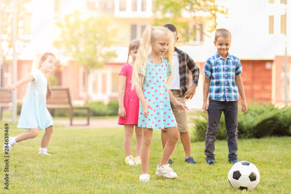 Cute little children playing football in park Cute little children playing football in park