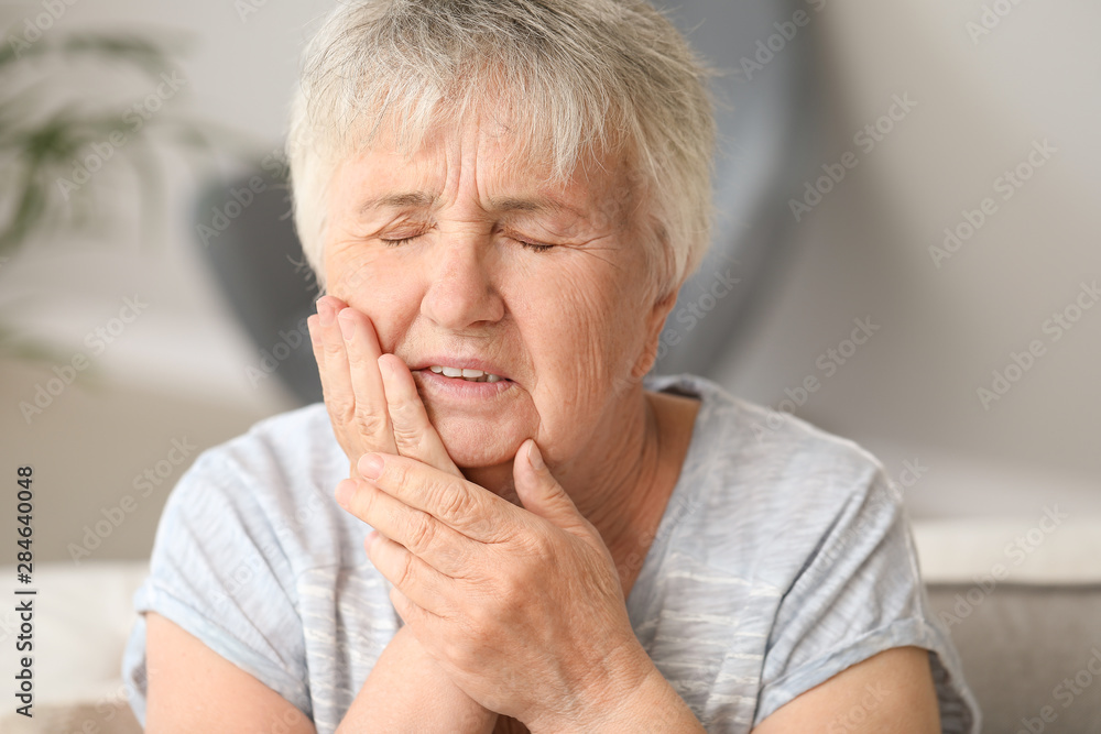 Senior woman suffering from toothache at home Senior woman suffering from toothache at home