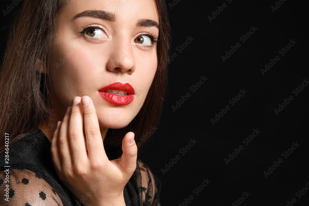 Beautiful young woman with bright lipstick on dark background Beautiful young woman with bright lipstick on dark background