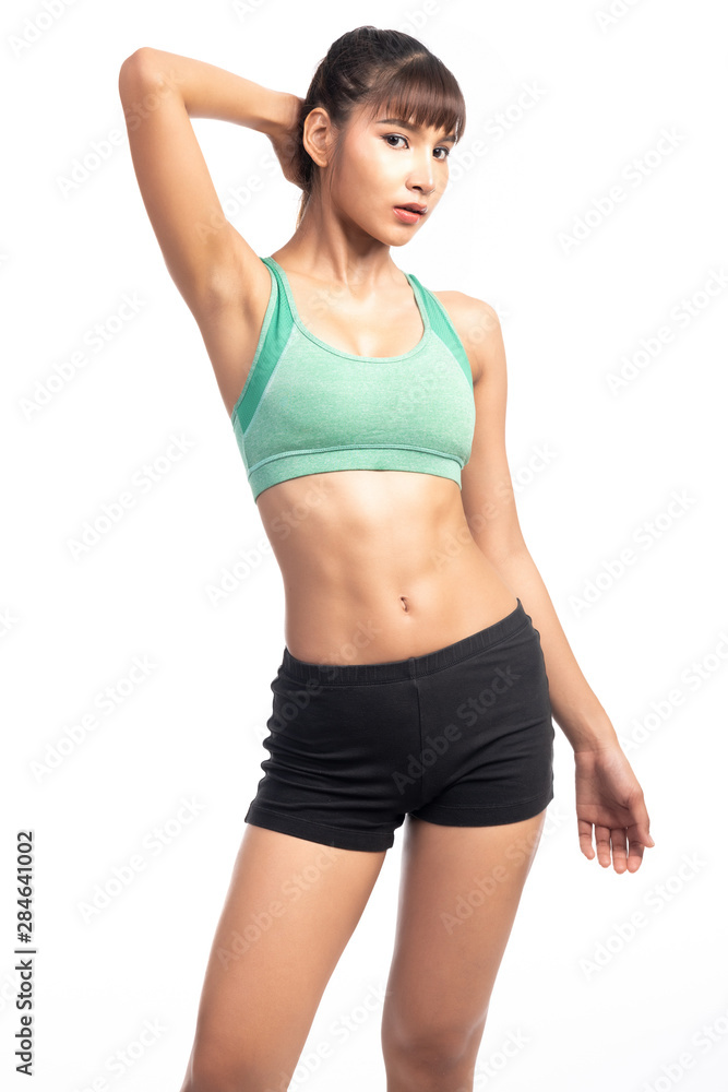 Fitness woman white background. Asian woman. Hand behind neck. Looking at camera.