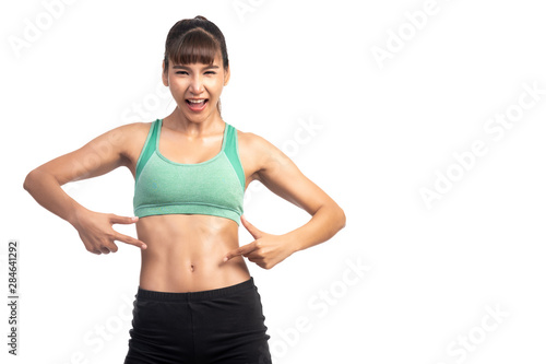 Fitness woman white background. Asian woman. Focus on her six pack muscle, pointing finger.