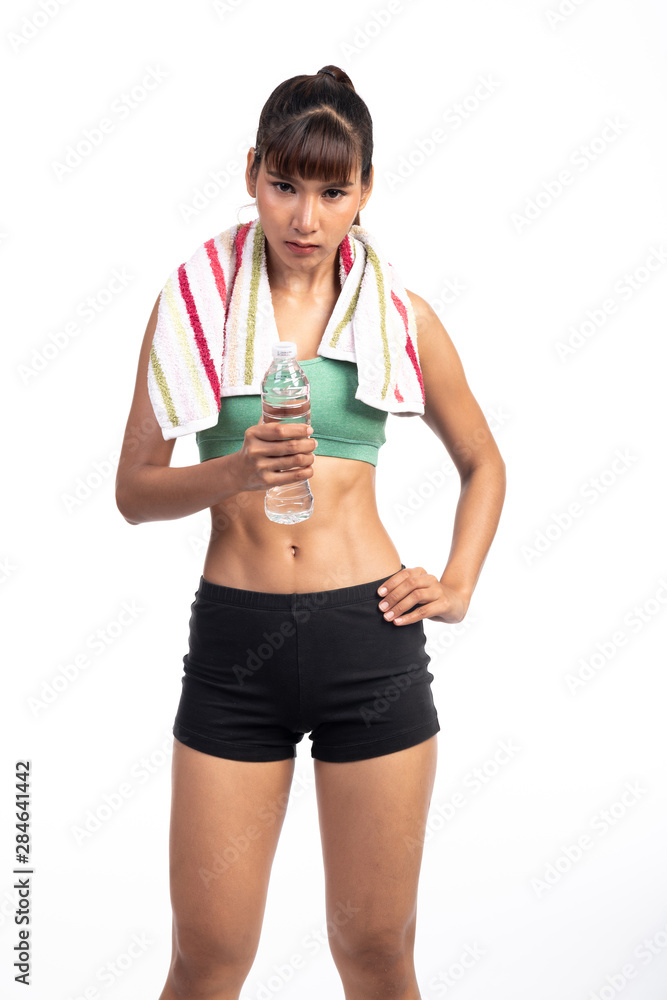 Fitness woman resting isolate in white background. Asian girl with water bottle and towel. Intense look. Fitness woman resting isolate in white background. Asian girl with water bottle and towel. Intense look.