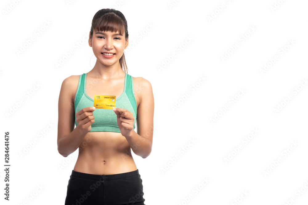Fitness woman holding credit card isolated in white background. Asian girl, very happy smile. Fitness woman holding credit card isolated in white background. Asian girl, very happy smile.