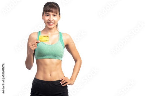 Fitness woman holding credit card isolated in white background. Asian girl, happy smile. © Baan Taksin Studio