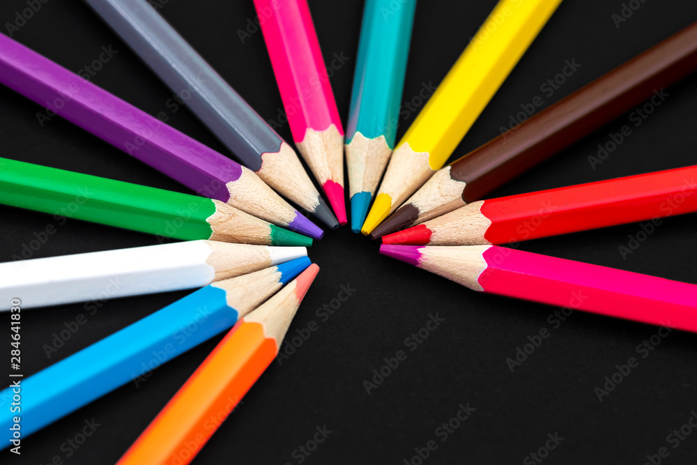 Colored pencils isolated on black background. Close up