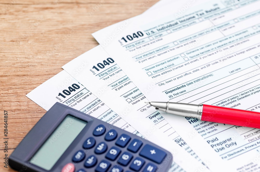 1040 tax form with calculator and pen 1040 tax form with calculator and pen