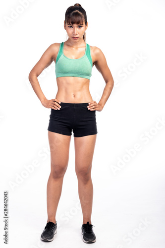 Fitness woman isolated in white background. Asian girl in full body pose. Focus mood.