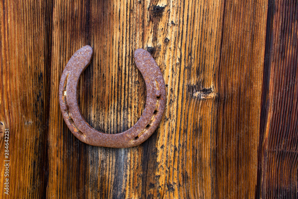 old rusty horseshoe on a wooden wall surface old rusty horseshoe on a wooden wall surface
