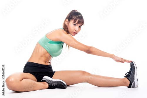 Fitness woman stretching isolated in white background. Asian girl in full body shot. Hip stretch, focus look.
