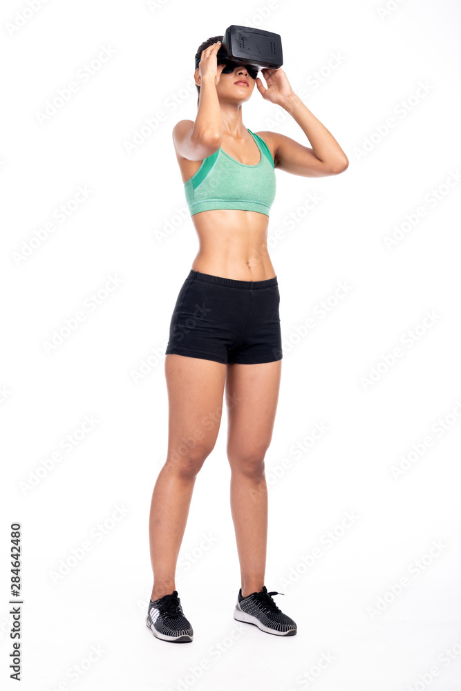 Fitness woman wearing VR headset isolated in white background. Asian girl, full body shot, side shot, intense exciting look. Fitness woman wearing VR headset isolated in white background. Asian girl, full body shot, side shot, intense exciting look.