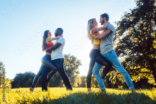Women and men having fun dancing in the park