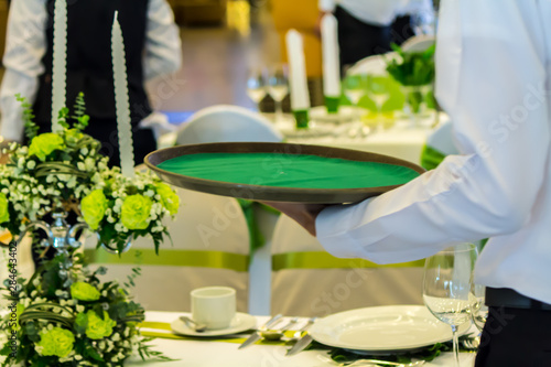 Waiter decorate and setting luxury party dinner table in restaurant.