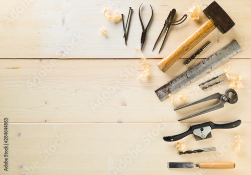 Collection of old, used wood working tools flat lay from above on wooden background with copy space - repair, craftsmanship or workshop concept