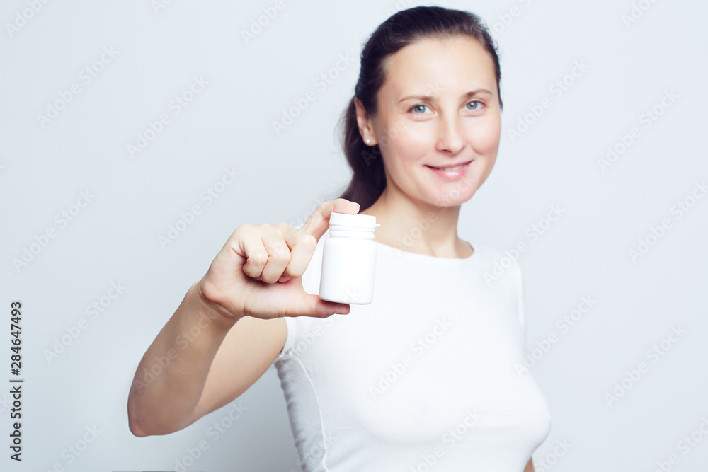 Woman holding white plastic pill bottle selective focus Woman holding white plastic pill bottle selective focus