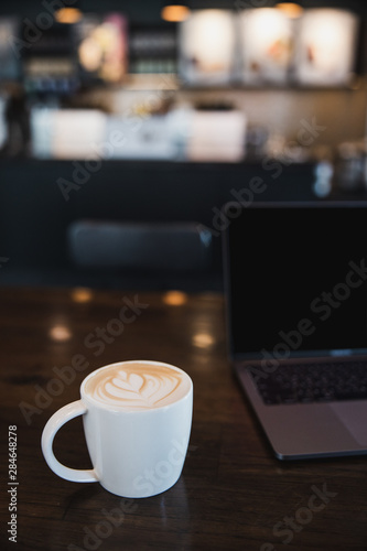 cup of coffee latte on wooden table in a cafe