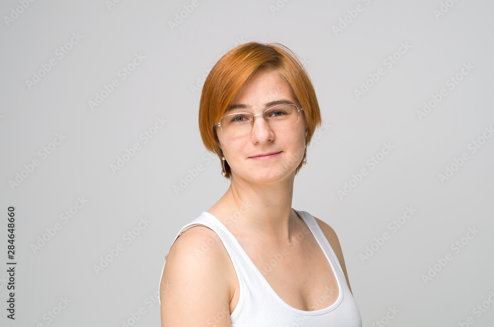 The light casual portrait of young woman with ginger hair and in glasses The light casual portrait of young woman with ginger hair and in glasses