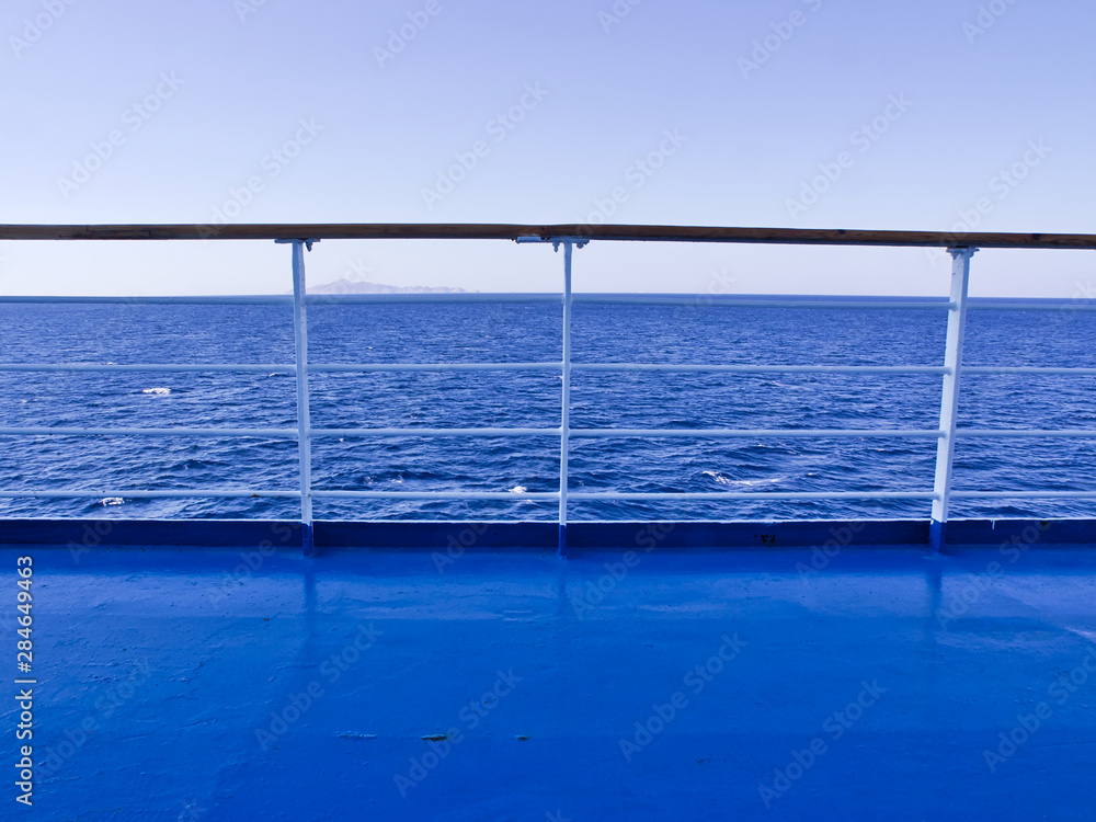 Ferry deck and railings with sea and horizon line background.