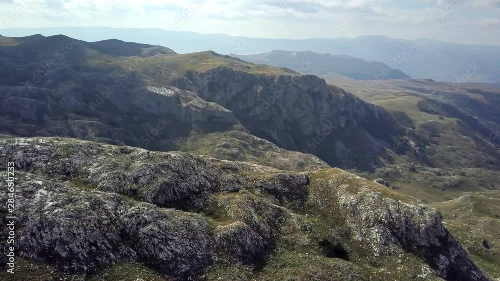 Aerial view of drone flying over patched two lane in Montenegro hills and fields with rocks on background in 4k resolution Aerial view of drone flying over patched two lane in Montenegro hills and fields with rocks on background in 4k resolution