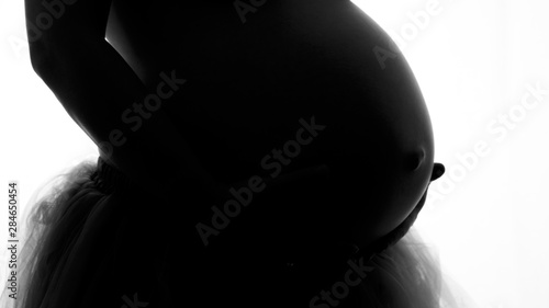 belly of pregnant woman on black background