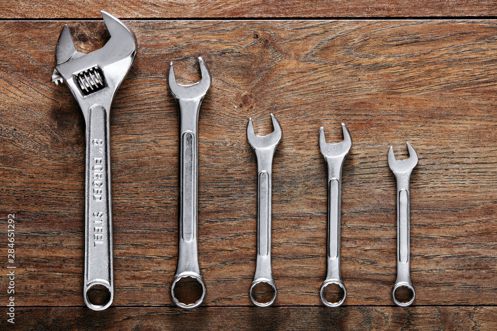 Set of wrenches tiered on wooden table background. Set of wrenches tiered on wooden table background.