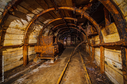 Underground mining tunnel with rails. Copy space. Work in an underground coal mine