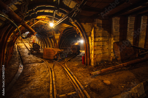 Underground mining tunnel with rails. Copy space. Work in an underground coal mine