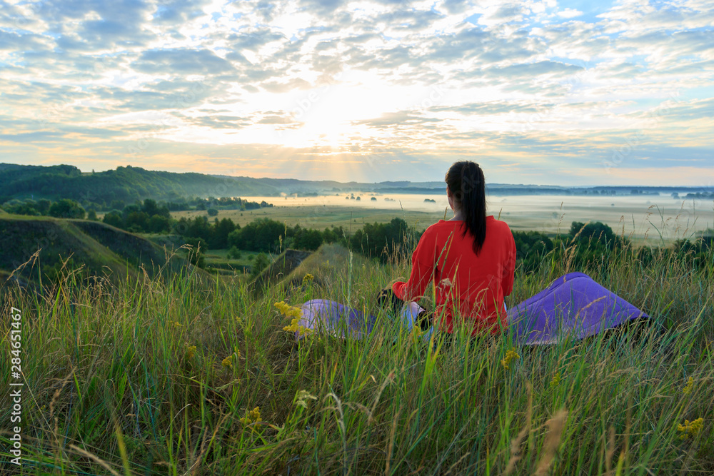 Fototapeta premium Girl in the nature doing yoga exercise for fitness.