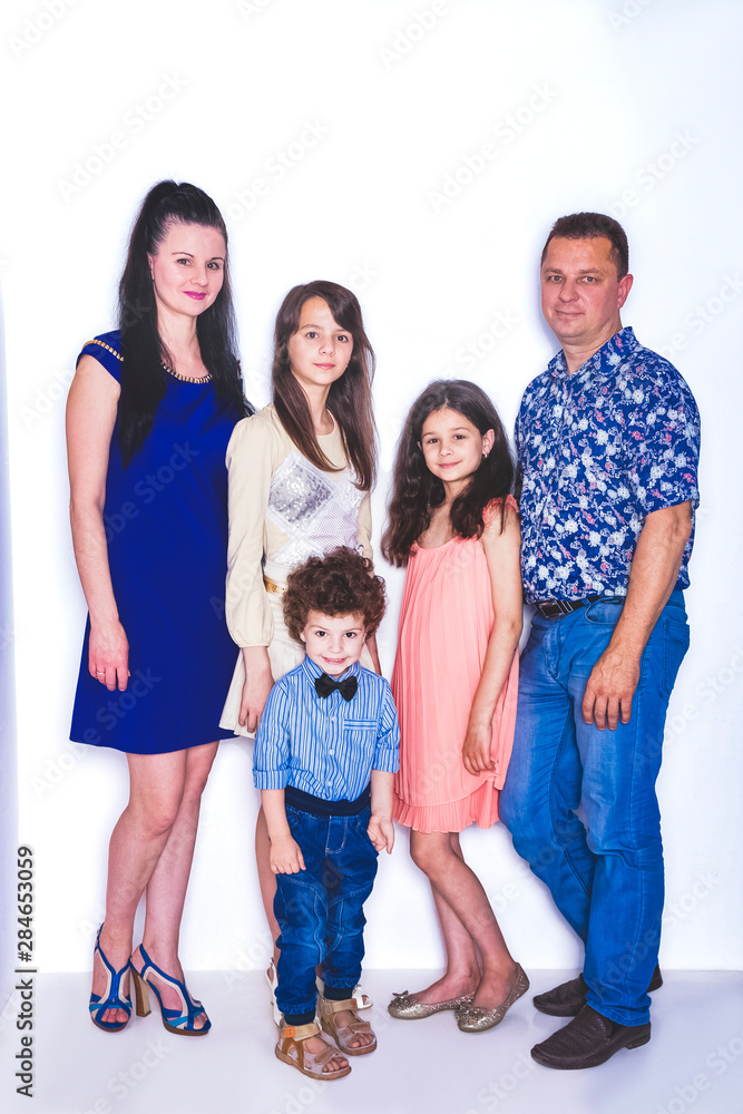 Family Studio Portrait, Happy Parents and Three Children with Baby on Light Background Family Studio Portrait, Happy Parents and Three Children with Baby on Light Background