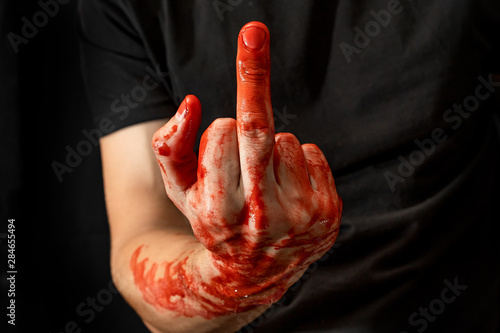 Male hands showing various gestures in the blood on a black background. fuck off, middle finger up photo