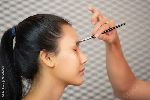 Close up beautiful asian woman applying make up.