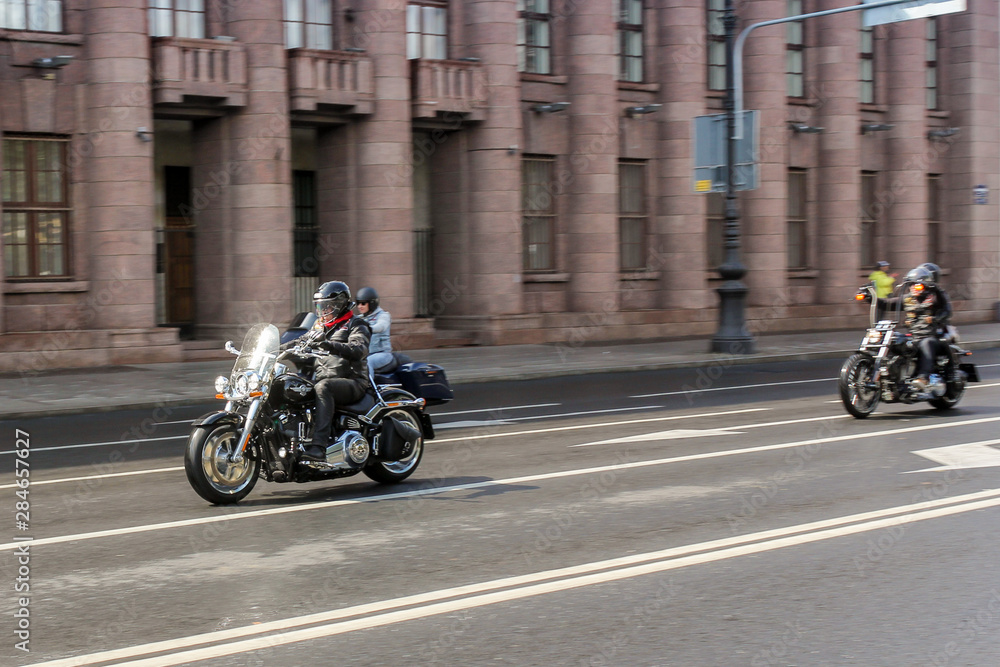 A group of motorcyclists at speed in motion.