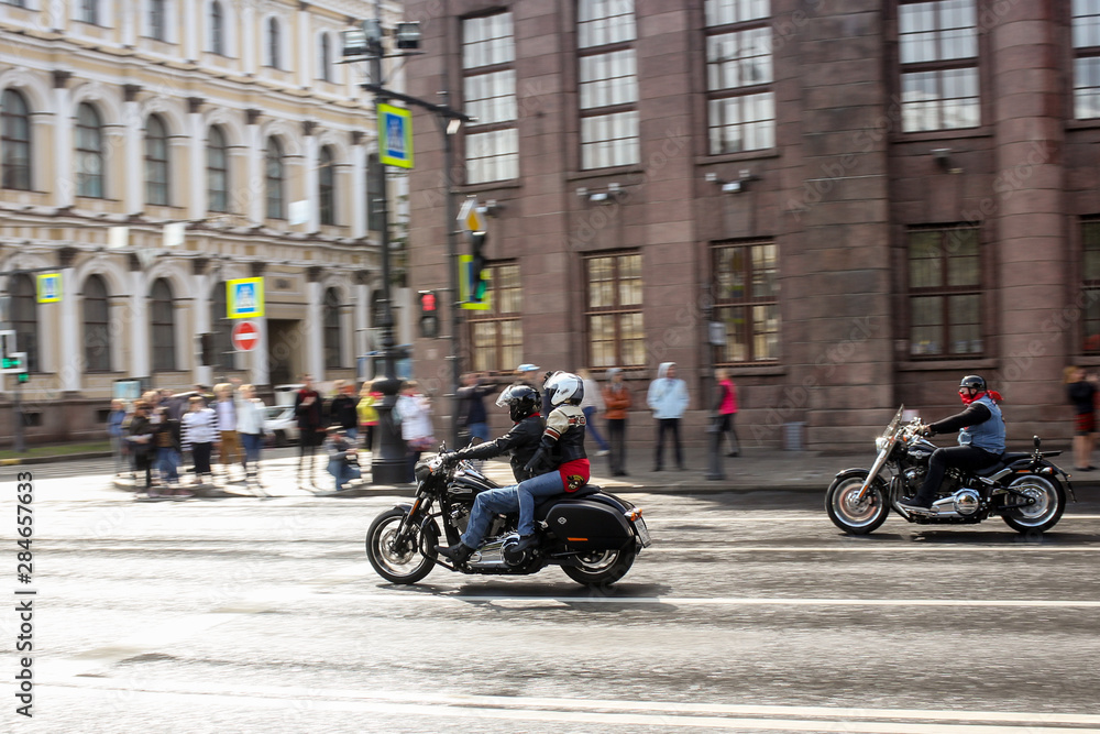 A pair of motorcyclists pulls up to an intersection.