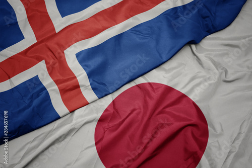 waving colorful flag of japan and national flag of iceland.