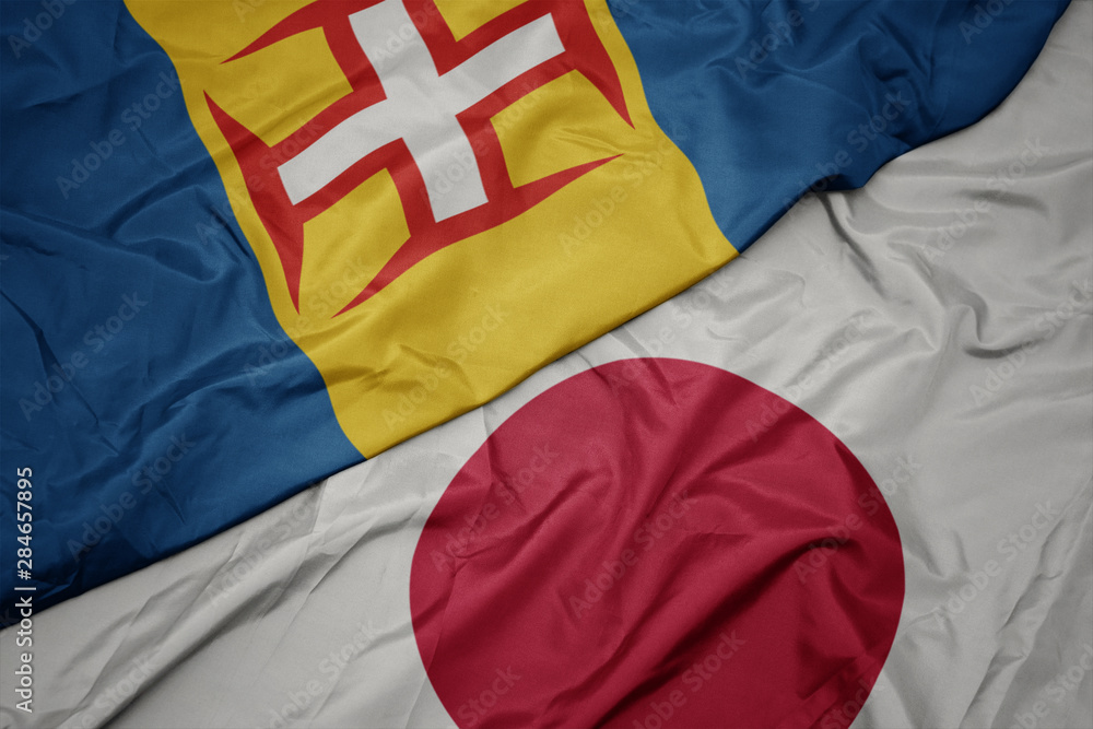 Fototapeta premium waving colorful flag of japan and national flag of madeira.
