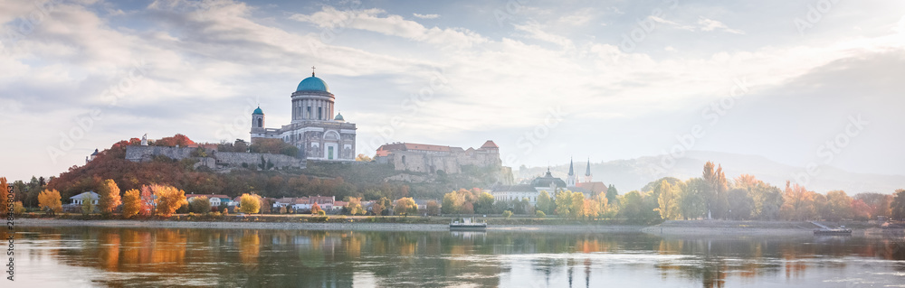 Esztergom, Hungary, view on Basilica. Beautiful light Morning misty panorama over Danube river on border of Hungary and Slovakia. Banner for web-design format photo. Autumn season, yellow trees.
