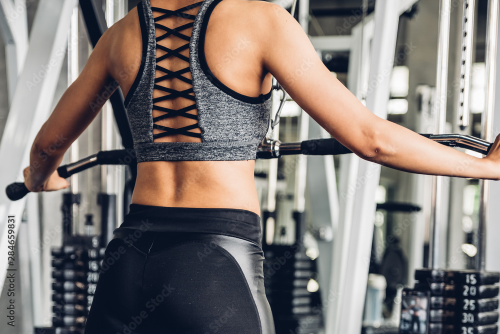 Close up attractive young sports asian woman lifting weight in gym. Close up attractive young sports asian woman lifting weight in gym.