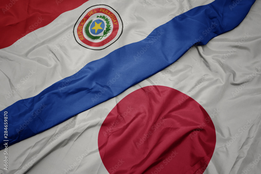 Fototapeta premium waving colorful flag of japan and national flag of paraguay.