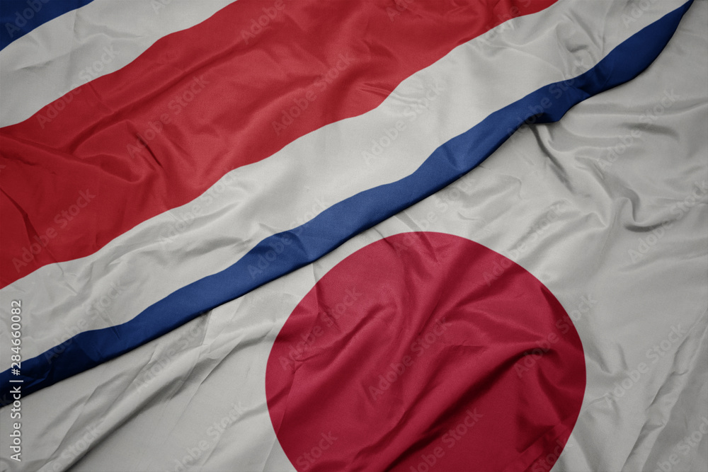 waving colorful flag of japan and national flag of costa rica. waving colorful flag of japan and national flag of costa rica.