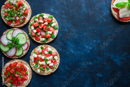 various healthy sandwiches with rice crisp cake chopped tomatoes radish cucumber basil cheese green onion top view copy space