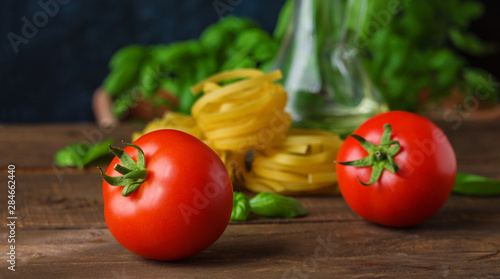 ripe tomatoes raw fettuccine basil ingredients for cooking vegetarian pasta close up