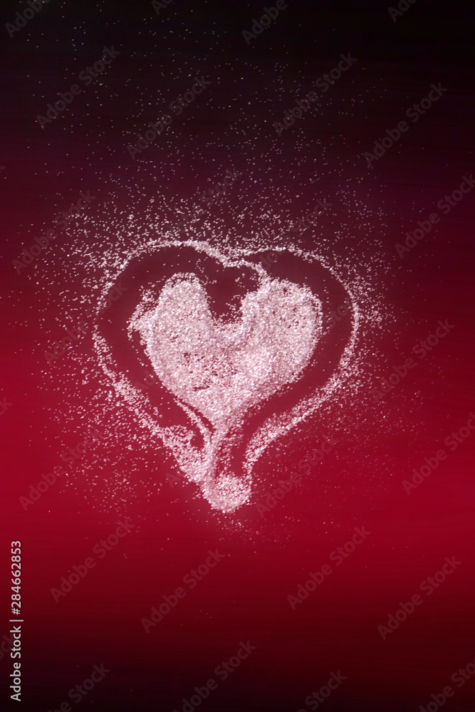 Heart of glitter on red background