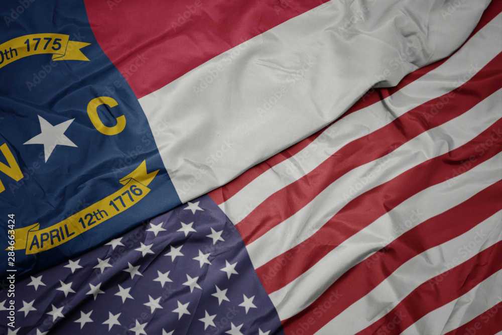 Obraz premium waving colorful flag of united states of america and flag of north carolina state.