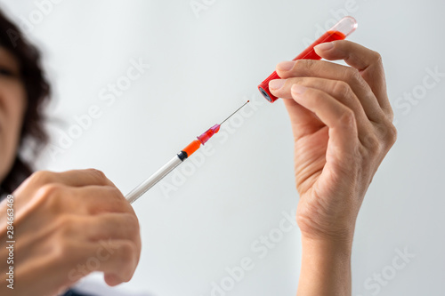 Female doctor holding syringe and vaccine