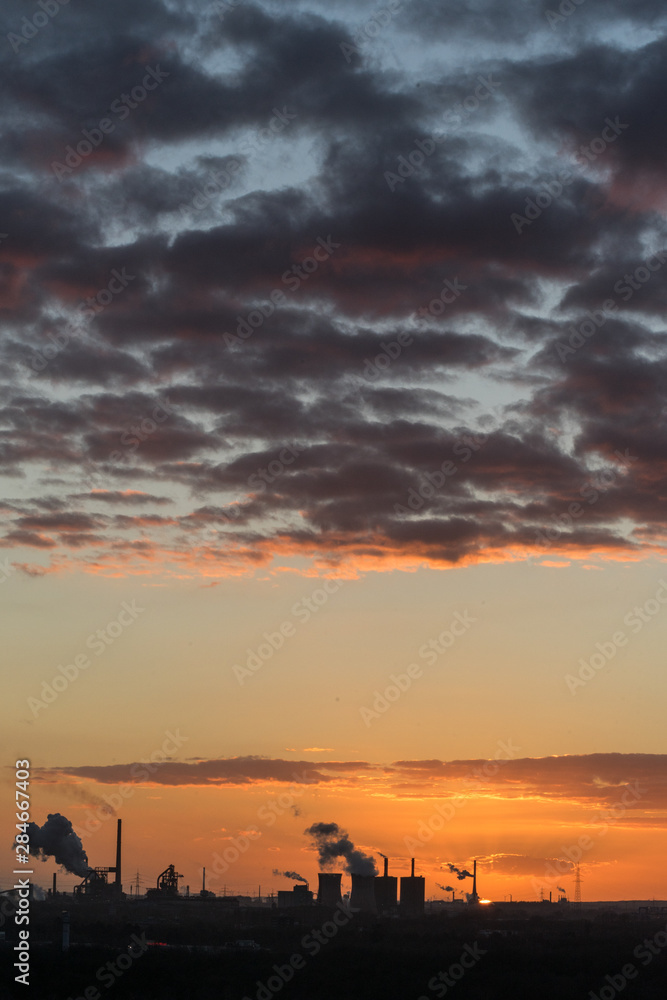 Sonnenuntergang an der Sechs-Seen-Platte in Duisburg mit Blick auf die rauchenden Schlote am Horizont