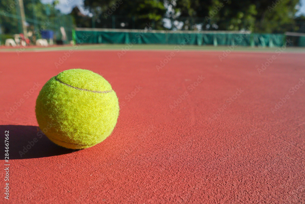 Tennis ball on the tennis court.Tennis balls are covered in a fibrous felt which modifies their aerodynamic properties