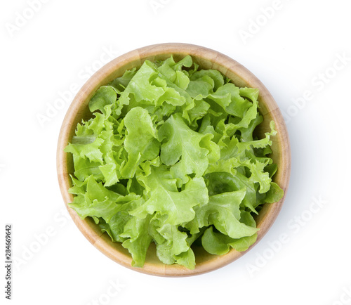 lettuce leaf in wood bowl isolated on white background. top view