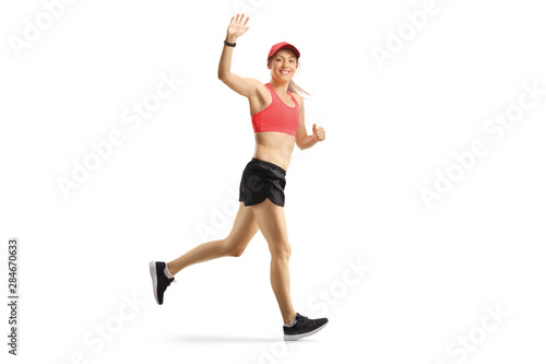Young female in sportswear jogging and waving a the camera © Ljupco Smokovski