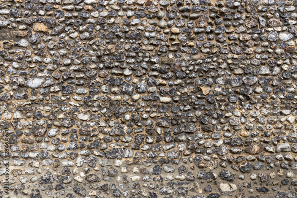 Layered flint pebble stone wall texture graphic resource Stock Photo
