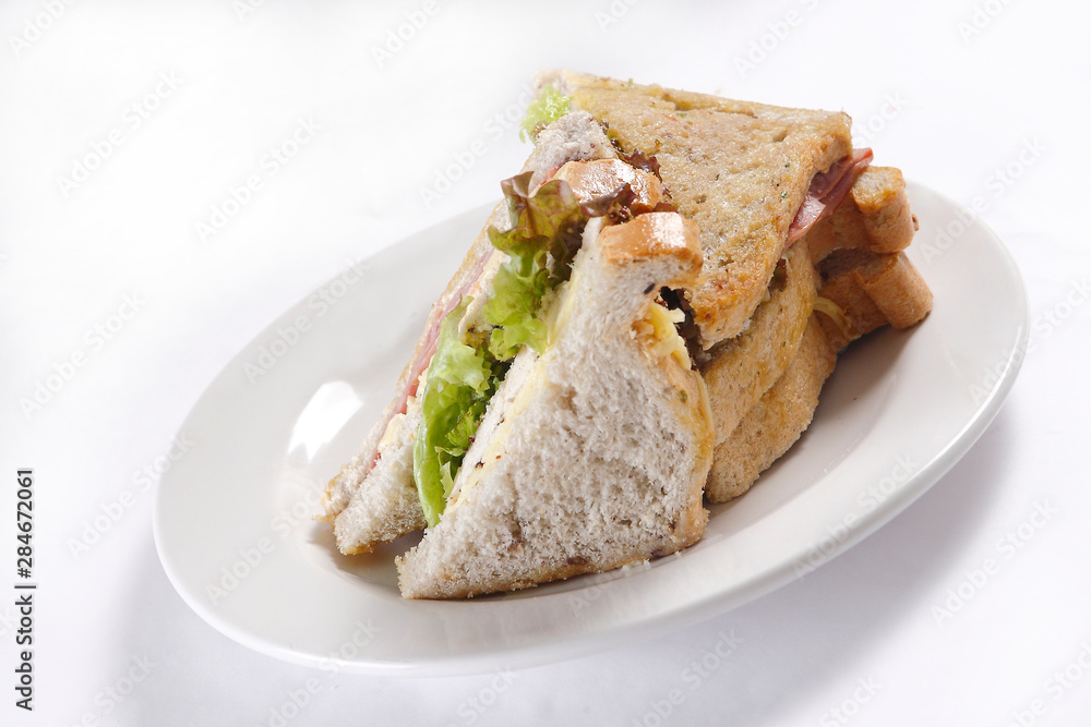 A sandwich club, also called a clubhouse sandwich, is a sandwich of bread, sliced cooked poultry, or fried bacon, lettuce, tomato, and mayonnaise. A sandwich club, also called a clubhouse sandwich, is a sandwich of bread, sliced cooked poultry, or fried bacon, lettuce, tomato, and mayonnaise.