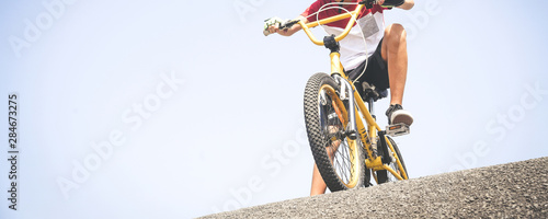 Young cyclist with bmx ready to start. Trendy young boy no face riding a bicycle looking the race track. Child having fun outdoor in the park. Competition, youth, brave, sport, outdoors concept